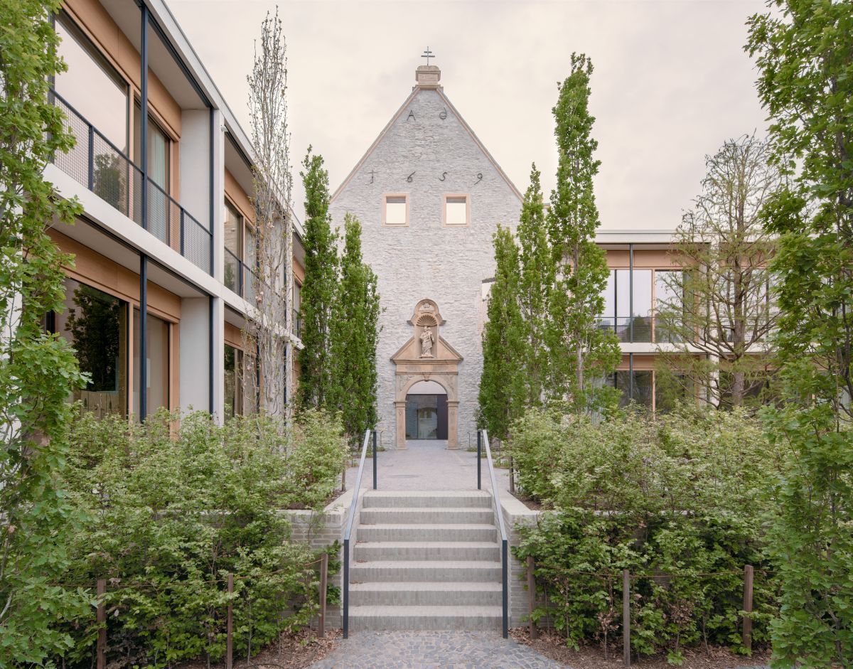Aerial view of a modern building complex with green roofs, surrounded by trees. The Headquarters of TAP Holding.